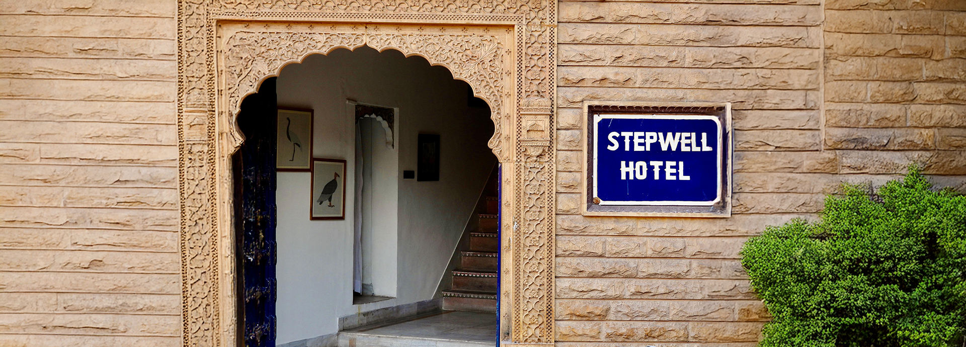 Traditional entrance to The Stepwell House showcasing intricate stone carvings.