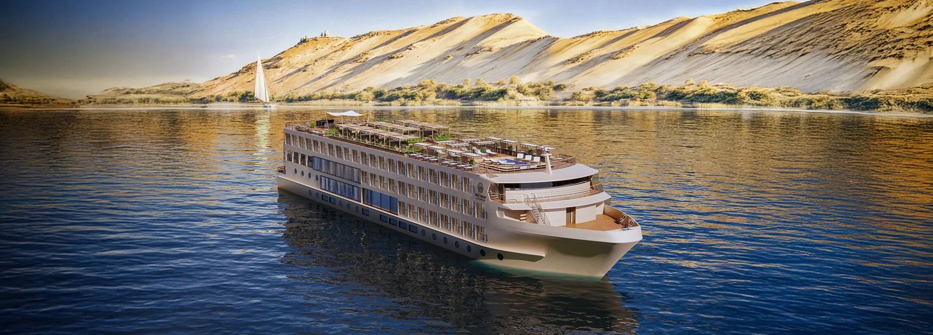 A&K Sanctuary Nile Seray cruising the Nile beneath golden desert dunes, with calm waters reflecting the light and a traditional felucca sailing nearby.