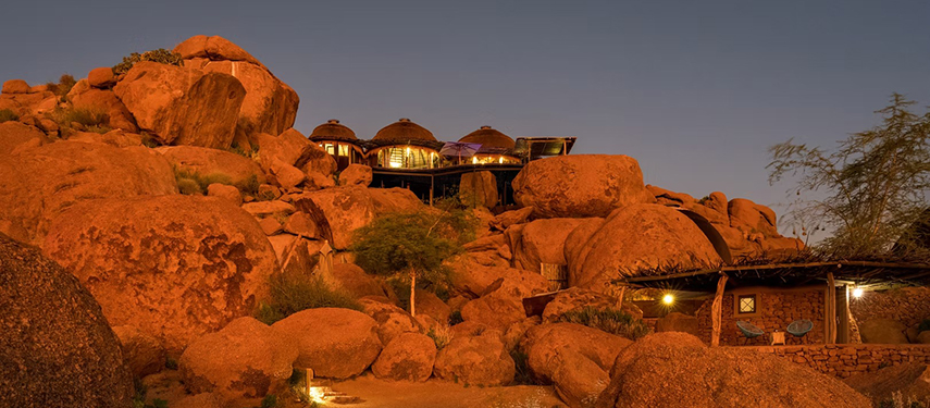 Luxury safari lodge perched atop the red boulders of the Namibian landscape