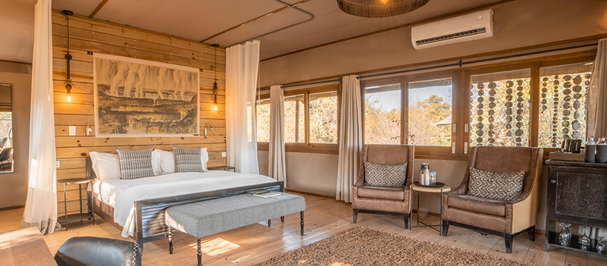 Sunlit bedroom interior at Toka Leya Camp with riverine forest views