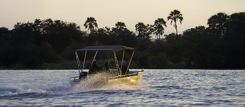 Guests on a boat safari heading out at dusk on the Zambezi River