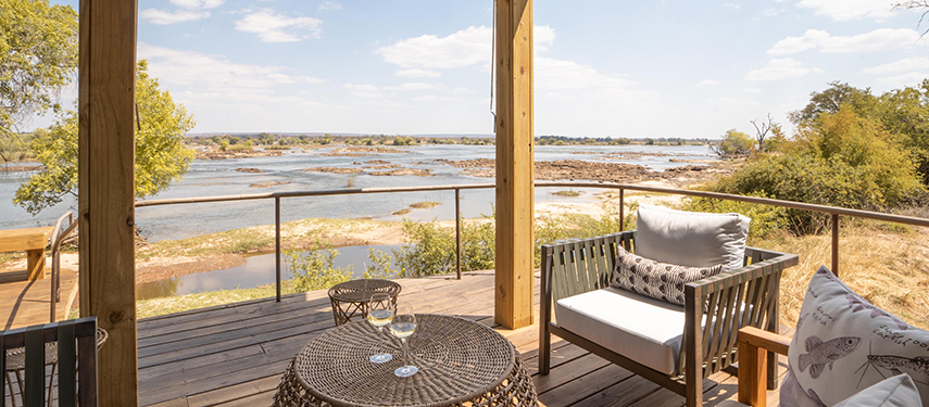 Private deck at Toka Leya with wine glasses and panoramic river outlook