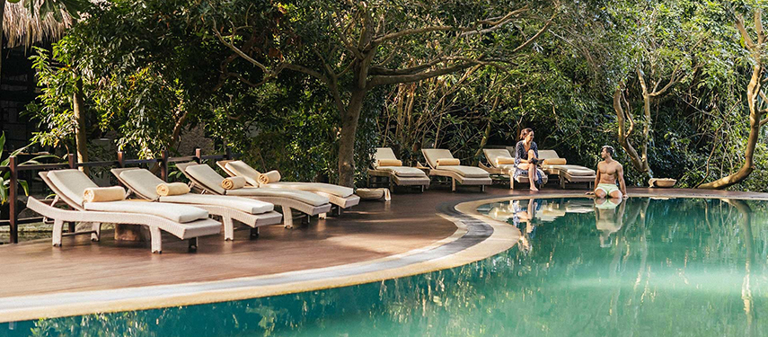 Luxurious pool surrounded by trees at Uga Jungle Beach resort