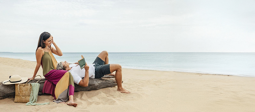 Couple relaxing on a pristine sandy beach in Sri Lanka
