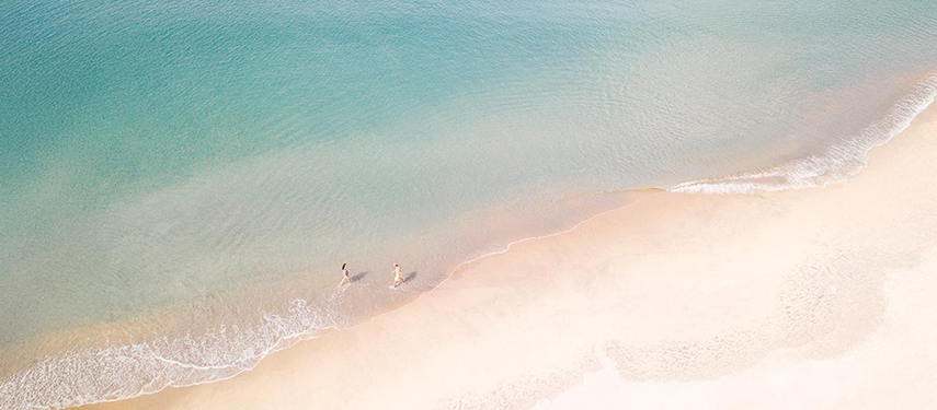 Aerial view of couple taking a romantic stroll on a Sri Lankan beach