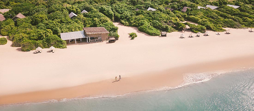 Aerial view of couple taking a romantic stroll on a Sri Lankan beach