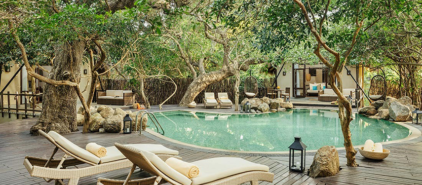 Luxurious pool surrounded by trees at Uga Jungle Beach resort