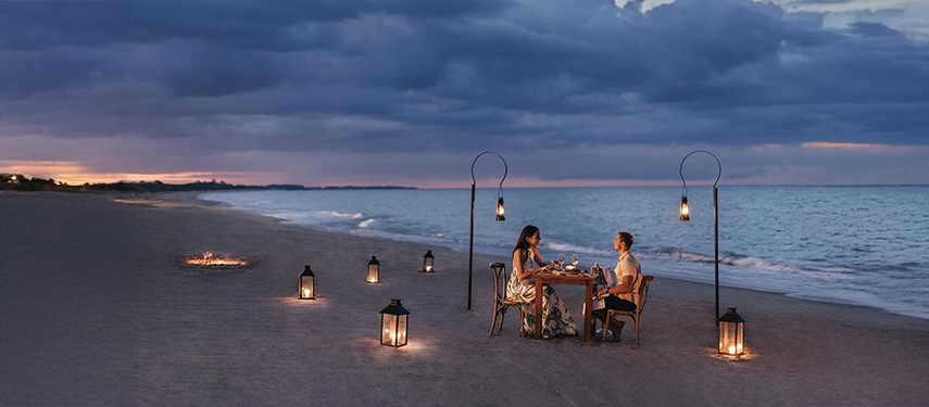 Couple enjoy a romantic dinner on a Sri Lankan beach