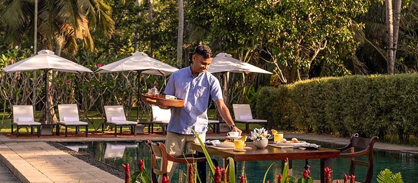 Waiter serves breakfast at a luxurious colonial-style hotel in Sri Lanka