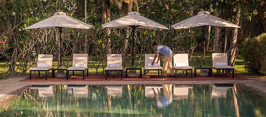 Swimming pool surrounded by trees at a luxurious colonial-style hotel in Sri Lanka