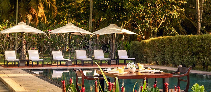 Swimming pool surrounded by trees at a luxurious colonial-style hotel in Sri Lanka