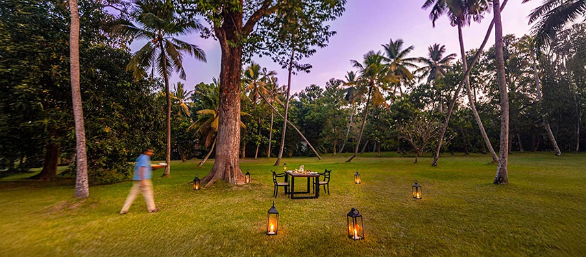 Waiter serves lamp-lit dinner at a luxurious colonial-style hotel in Sri Lanka