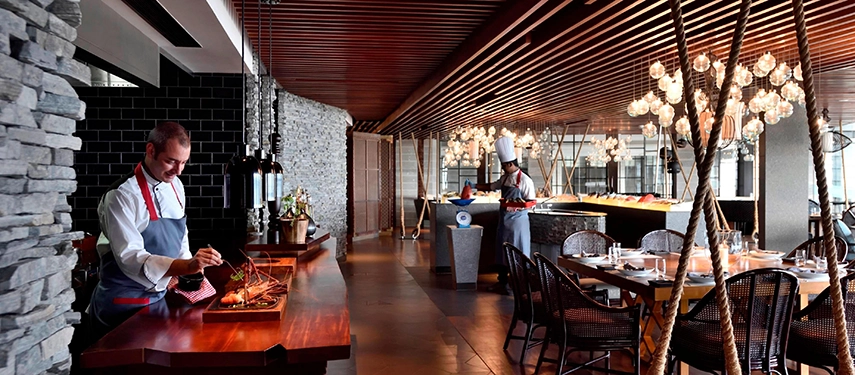 Chefs prepare fresh seafood at a live cooking station inside the vibrant dining area at Weligama Bay Marriott Resort & Spa.