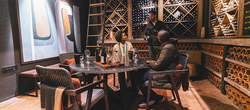 Couple enjoys a wine tasting with a sommelier in a wine cellar