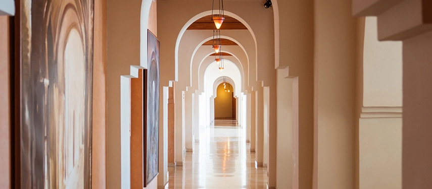 legant arched hallway with hanging lanterns and polished floors inside The Residence Tunis.