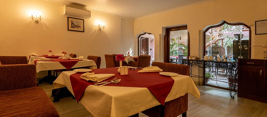 Indoor dining room with maroon and white table settings, overlooking the central courtyard.