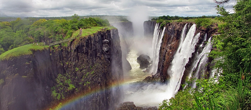 Victoria Falls plunges into the Batoka Gorge, framed by lush rainforest and drifting spray on the Zambian side of the Zambezi River.