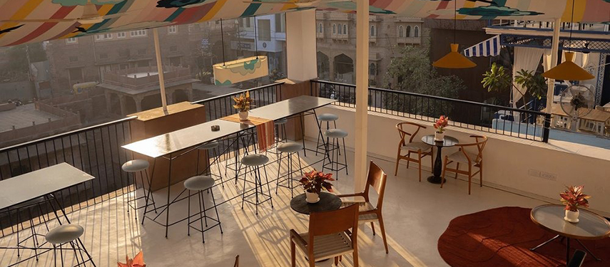 Chic open-air café space at The Stepwell House with colourful canopies and seating.
