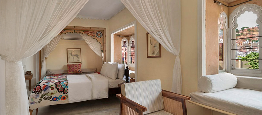 Inviting bedroom at The Stepwell House with a view over Jodhpur’s blue rooftops.