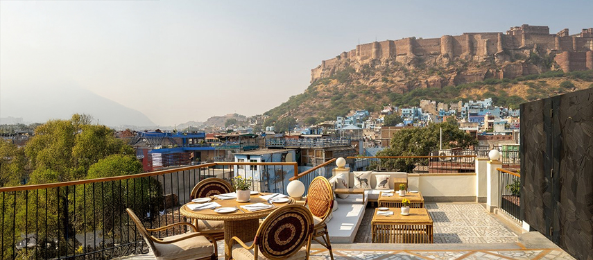 Rooftop dining terrace at The Stepwell House with panoramic views of Mehrangarh Fort.