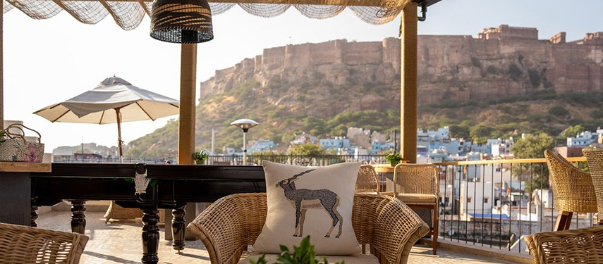 Cosy rooftop seating at The Stepwell House framed by a view of Mehrangarh Fort.