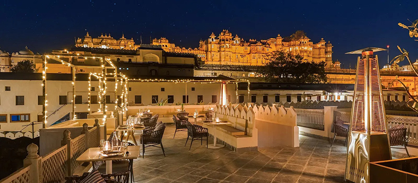 Rooftop dinner setting with fairy lights and panoramic palace views