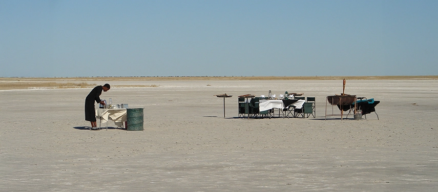 An elegant private dining setup awaits on the open salt pans near Moela, creating a striking and memorable wilderness setting.