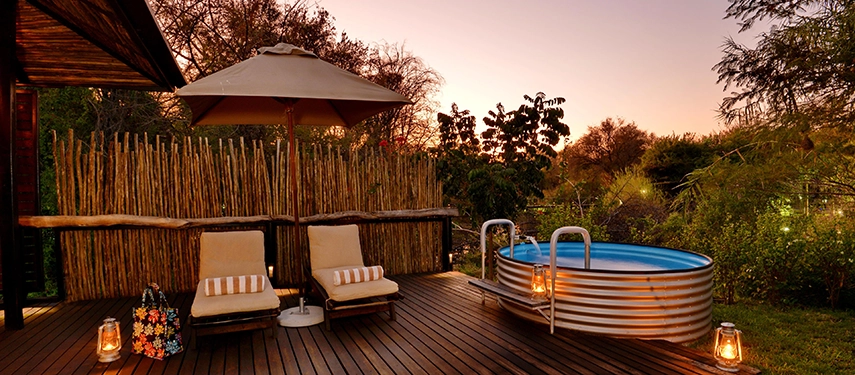 A private suite deck at Mukwa River Lodge features an outdoor plunge pool and loungers, set amid lush gardens in the soft evening light.