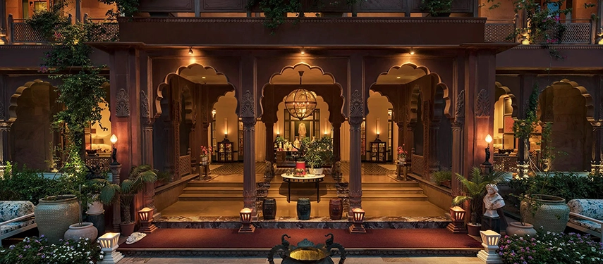 The richly decorated reception bar at Padmaa Haveli, glowing under ambient lighting in a deep red room.