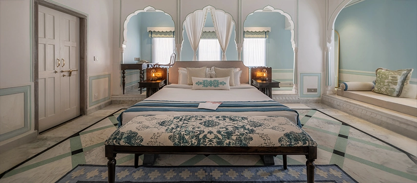 An elegant suite at Padmaa Haveli showcasing a king-size bed, traditional decor, and soft blue accents.