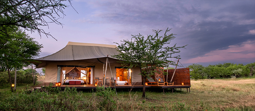 A private tented suite at Sayari camp as the sun sets over the Serengeti