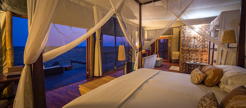 Interior of a luxury safari tent at Shumba Camp with views across the plains at dusk
