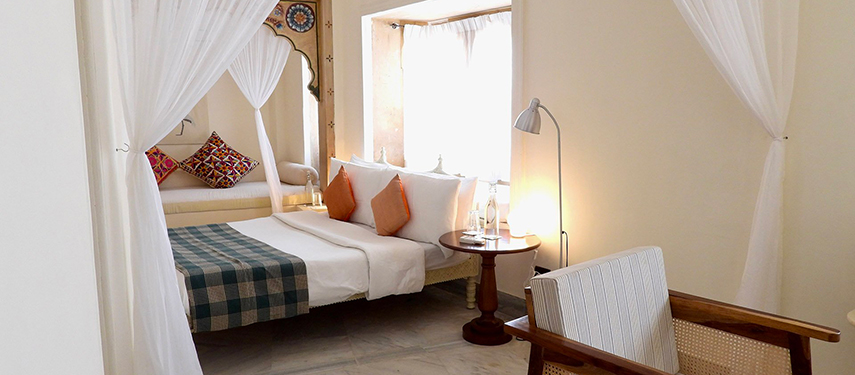 Bright, airy guestroom at The Stepwell House with heritage decor and vibrant accents.
