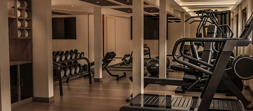 A modern fitness centre aboard A&K Sanctuary Nile Seray, featuring cardio equipment, free weights and softly lit interiors with warm timber floors.