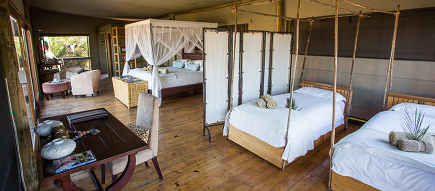 Multi-bed tented suite with rustic furnishings, ideal for families or groups